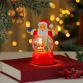 Festive glowing Santa Claus snow globe music box ornament displayed on a red book - Santa with Tree (11*8*16cm 580g)