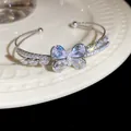 Detail showing the sparkling zirconia butterfly and pearl center on the double-layer cuff - Clear Butterfly / Silver