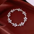 Detailed close-up of sparkling zircon flower bracelet on elegant red silk background. - Flower Style / Silver-White