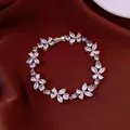 Close-up of silver flower bracelet with pink and clear zircon stones on brown fabric. - Flower Style / Silver-White-Purple