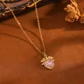 Nahaufnahme einer Goldkette mit herzförmigem rosa Kristallanhänger und Zweigen - Goldene rosa Strass-Herzblatt-Kette (T076)