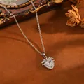 Nahaufnahme eines herzförmigen Erdbeeranhängers mit Kristallen auf einem braunen Hintergrund. - Silberne weiße Strass-Herzblatt-Kette (T076)
