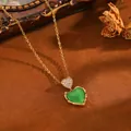 Nahaufnahme einer eleganten goldenen Edelstahlkette mit grünem Herz-Anhänger - Goldene Doppelherz-Halskette mit grünem Strass (T076)
