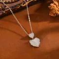 Nahaufnahme der Herzkette mit Katzenaugenstein und funkelnden Kristallakzenten - Silberne Doppelherz-Halskette mit weißem Strass (T076)