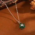 Detailansicht einer eleganten Blumenhalskette mit grünen und weißen Edelsteinen - Silberne Halskette mit weißem Herz und grüner fünfblättriger Blume (T077)
