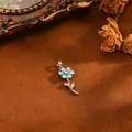 Detailansicht eines hellblauen Blumenanhängers mit Zirkon auf Vintage-Hintergrund. - Blaue Strass Blume (T069) / Silber