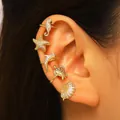 Gold ocean-themed ear cuffs set with seahorse and starfish designs on a human ear - Ear Cuffs (5-Piece Set) / Gold