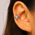 Close-up view of a silver turtle ear cuff with sparkling zircons worn on the ear cartilage - Sea Turtle (10924) / Silver