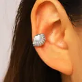 Close-up of a silver shell ear cuff with pavé zircons worn on the ear cartilage. - Shell (2766) / Silver