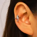 Close-up of a silver seahorse ear cuff with sparkling zircons on a model's ear - Seahorse (1271) / Silver