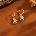 Close-up of gold-plated teardrop earrings with crystals and hoop clasp details - Water Drop Earrings / Gold
