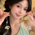 Asiatisches Model mit eleganten Blumen-Quasten-Ohrringen mit grünen Perlen und Zirkon - Grün