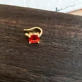 Κοντινό πλάνο χρυσού ear cuff με μια στρογγυλή κόκκινη πέτρα ζιργκόν - Μονό Τεμάχιο / Χρυσό / Κόκκινο (Επίχρυσο 18K)