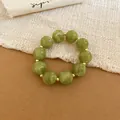 Detailed view of olive green acrylic beaded bracelet with marble pattern and gold spacers - Bracelet / Green