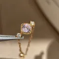Detailopname van een vintage ring met vierkante roze edelsteen en gouden ketting - Fijne Kettingstijl met Vierkante Edelsteen (K1203) / Goud-Roze
