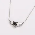Detailed view of angel wing heart pendant with central projection stone in silver finish - Steel