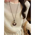Retro dark wood resin oval hollow pendant necklace for women worn on beige knit - Coffee & Black - Oval