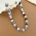 Detailed view of the marble pattern acrylic beads and gold spacers on this elegant necklace. - Ink Marble Round Bead Necklace (47#) / Gold-Ink Clear