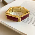 Close-up of vintage gold and red resin rectangular links on an elastic bracelet. - Red
