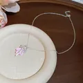 Close-up of pink enamel bow necklace with sparkling zircon flower pendant for women. - Silver Style (Pink Bow)