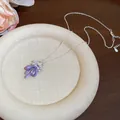Detailed close-up of a purple enamel bow necklace with sparkling zircon flowers. - Silver Style (Purple Bow)