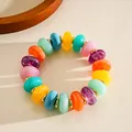Close-up of a colorful marbleized acrylic bead bracelet with golden spacers. - Bracelet / Colorful