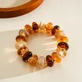 Close-up of vintage acrylic beaded bracelet with amber marbled swirl effect and gold spacers - Bracelet / Amber