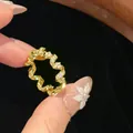 Primo piano dettagliato di un anello a spirale in oro con pavé di pietre brillanti - Stile Zirconia Intrecciata / Oro