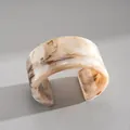 Detailansicht eines unregelmäßigen geometrischen Manschettenarmbands aus Marmorharz - Marmortextur Breiter Band Stil / Beige Marmor
