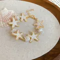 Detailed macro view of gold plated ocean starfish bracelet featuring white pearls and beads - Starfish Pendant Ocean Style (67#手链) / Gold-White
