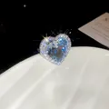 Detailopname van een luxe hartvormige open ring met sprankelende blauwe zirkonia - Halo Groot Hart Open Ring Stijl / Zilver-Blauw