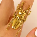 Primo piano dettagliato di un anello a forma di scarabeo dorato su un dito, vista macro. - Anello Aperto Scarabeo (3005)