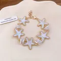 Elegant gold-tone starfish charm bracelet with pearl-like beads for seaside beach style - White