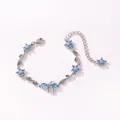 Vue détaillée du bracelet argenté avec fleurs et nœud en zircone bleue - Style Horizontal-Or Blanc-Zirconia Bleu Mer
