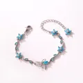 Détail en gros plan d'un élégant bracelet argenté avec nœud papillon et feuilles - Style Horizontal-Or Blanc-Zirconia Turquoise