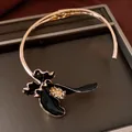 Nahaufnahme eines französischen Vintage-Chokers mit schwarzer Emaille-Blume und Strass - Gold Schwarz