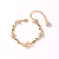 Vue détaillée d'un bracelet en or avec fleurs en zircon, feuilles vertes et nœud. - Style Horizontal-Or-Zirconia Blanche