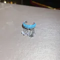 Close-up of a sparkling zircon starfish ear cuff with turquoise beads and dangles. - Starfish Tassel Ear Cuff (HE34044) / Blue Starfish Tassel