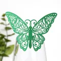 Détail d'une décoration de carte papillon verte ajourée sur le rebord d'un verre - Vert Foncé