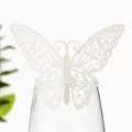 Vue détaillée d'un papillon en papier découpé au laser blanc utilisé comme décoration sur un verre - Ivoire