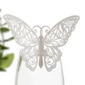 Gros plan d'un décor de papillon blanc découpé au laser sur le bord d'un verre - Argent