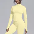 Detailed view of yellow long sleeve yoga jacket with stand-up collar and zipper. - Creamy Yellow
