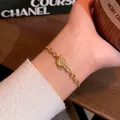 Elegant gold-plated titanium steel bracelet with a celestial Saturn charm on a wrist - S757 Gold - Cat's Eye Zirconia Planet Bracelet