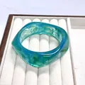 Stylish blue and green marbled resin bangle featuring a modern curved acrylic design - Teal Swirl Style