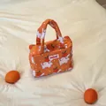 Detailed view of the cute orange pattern and 'mimi' label on the toddler tote bag. - Orange Dog