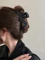 Professional large matte black hair claw clip with wave design shown on model's hair - Irregular Style / 13cm / Matte Black