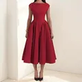 Detalle de la vista frontal de un vestido midi rojo sin mangas con escote barco y corte evasé - Burdeos