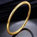 Minimalist polished gold titanium steel oval bangle with elegant hinged clasp closure. - Gold Round Line