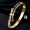 Detail view of gold stainless steel bangle with black and white crystal bow design - Gold + Black Zirconia