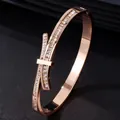 Bracciale a cerchio in acciaio inossidabile oro rosa con design a fiocco e cristalli. - Oro Rosa/Zirconia Bianca